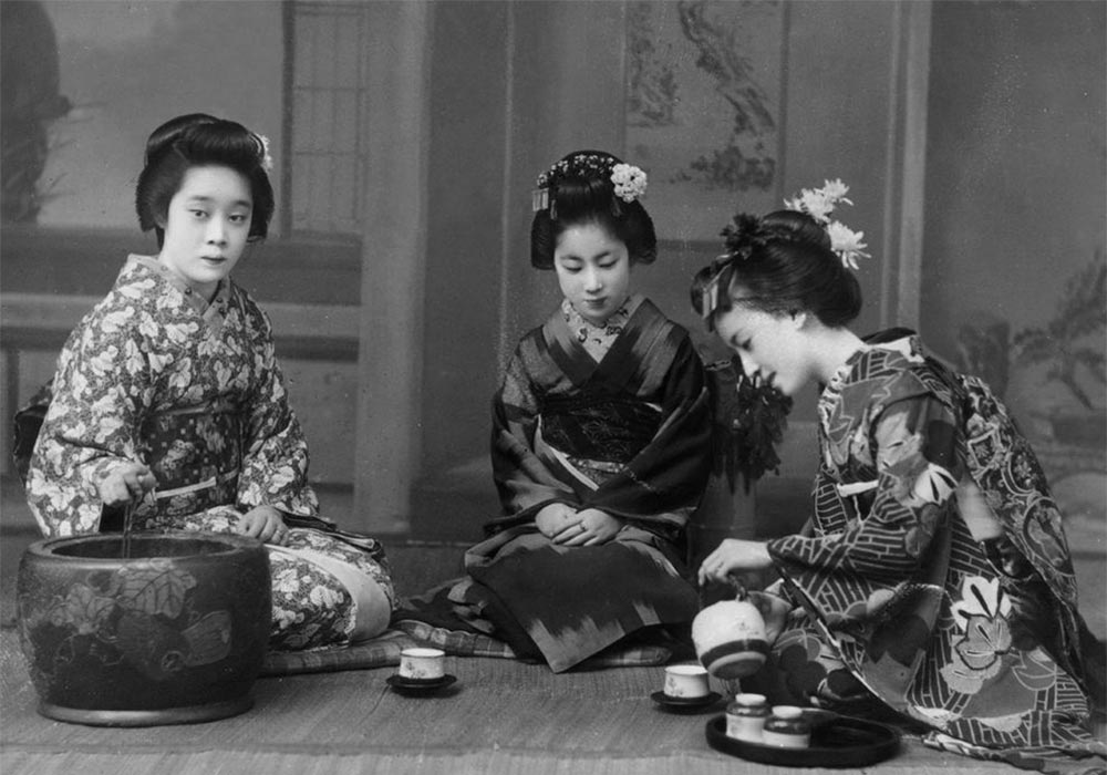 تصویری سیاه و سفید از سه زن با لباس سنتی ژاپنی درحال درست کردن چای